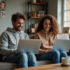 Couple assis sur un canapé avec laptops dans un salon cosy