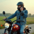 Homme en denim ajustant son casque sur une moto en campagne